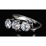 A modern silvery coloured metal mounted three stone diamond ring, the three brilliant cut stones,