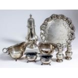 An Edward VII silver circular waiter, the shaped and moulded rim with shell and scroll mounts, on