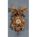 A German stained and carved "Cuckoo" clock, the 5.75ins diameter stained wood dial with applied