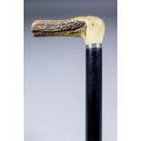 A late 19th/early 20th Century ebonised composite walking stick flick cane, with antler handle,