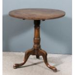An 18th Century mahogany circular tripod occasional table with plain one piece top, on turned