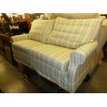 A MULTIYORK THREE SEATER SETTEE, COVERED IN CREAM AND GREEN STRIPED FABRIC (purchased 03/04/2012)