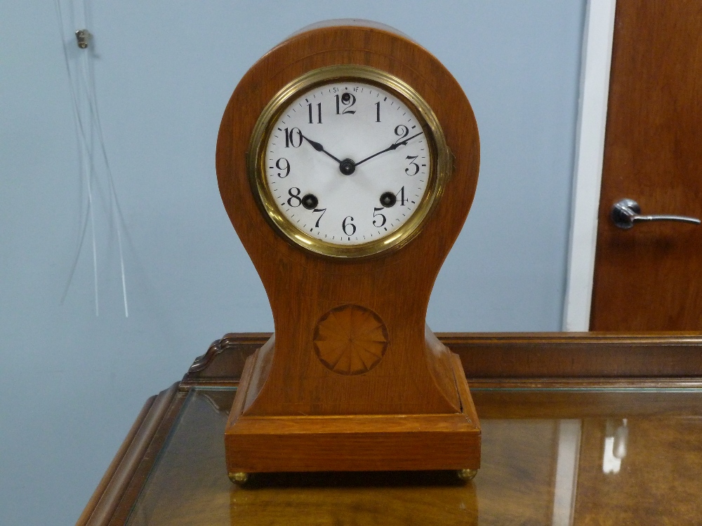 EDWARDIAN INLAID OAK MANTEL CLOCK in balloon shaped case, the 4" Arabic dial powered by an 'Ansonia'