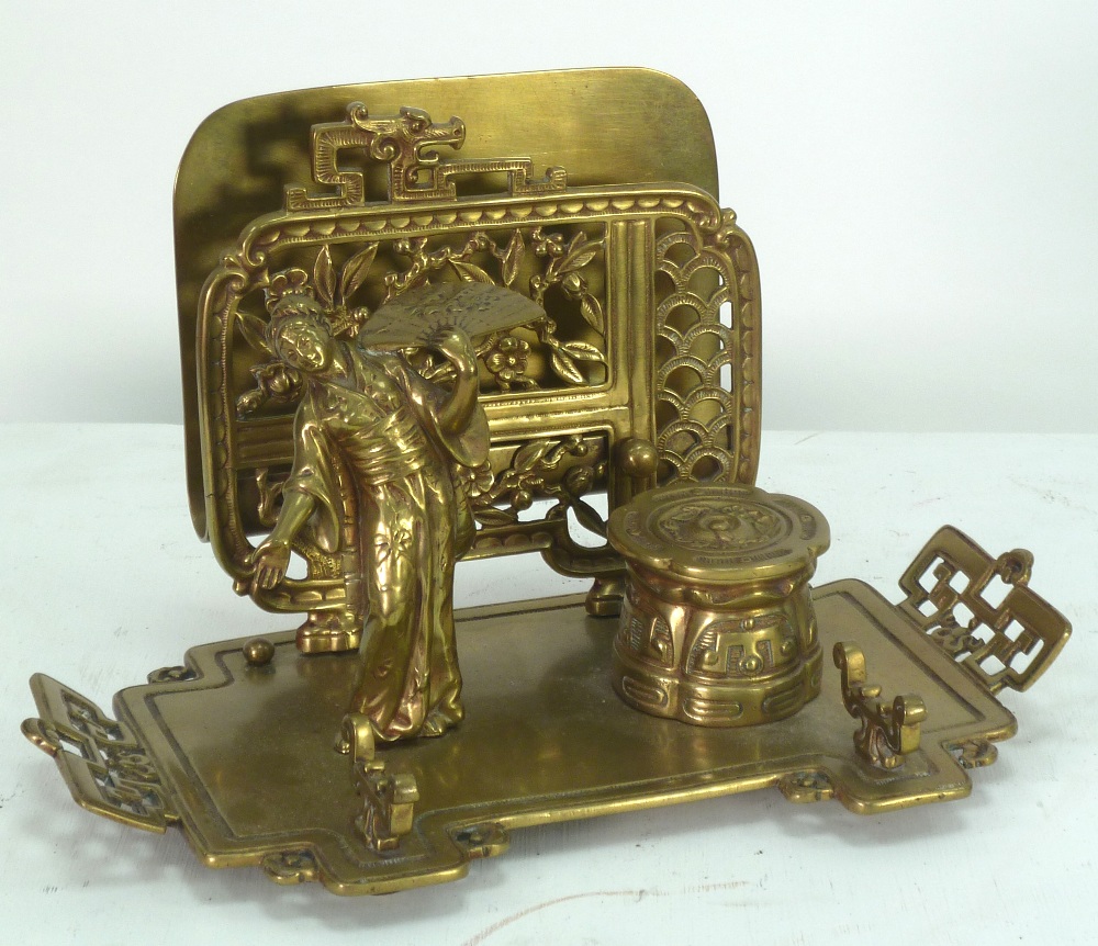 A LATE VICTORIAN CAST BRASS DESK STAND, with inkwell and letter rack, in the Japanesque style,