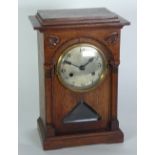 EARLY TWENTIETH CENTURY ARTS AND CRAFTS CARVED OAK MANTEL CLOCK, the 5" silvered dial powered by a