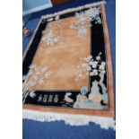 TWENTIETH CENTURY WASHED CHINESE CARPET, with gold ground and plain black borders, the design of