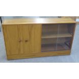 LOW, POSSIBLY TEAK, CUPBOARD AND BOOKCASE WITH SLIDING GLASS DOORS. HEIGHT 69CM, LENGTH 123CM.