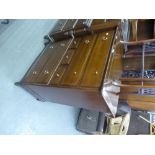 A STAGE MAHOGANY CHEST WITH FOUR LONG AND THREE SMALL CENTRAL DRAWERS WITH GILT BRASS RING