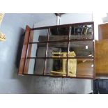 A MAHOGANY 'WATERFALL' TYPE OPEN BOOKCASE AND MAHOGANY FRAMED PANE PATTERN WALL MIRROR WITH