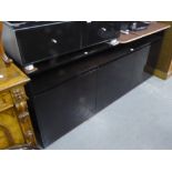 A STYLISH MODERN SIDEBOARD IN A BLACK GLOSS FINISH WITH TRIPLE CUPBOARDS BELOW AN OPEN SHELF. HEIGHT