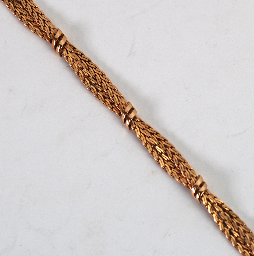 9ct GOLD BRACELET, of two entwined chevron pattern strands tied by five two strand ribbon cross