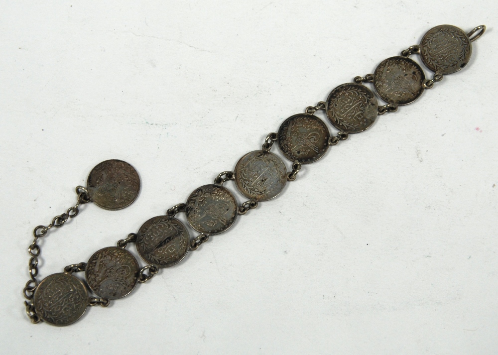MIDDLE EASTERN SILVER COIN BRACELET, formed of ten chain linked small silver coins, with hook