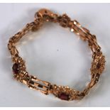 9ct GOLD GATE PATTERN BRACELET, with three fancy links of pierced oval flower pattern, each set with