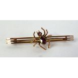 9ct GOLD TRIPLE BAR BROOCH, surmounted by a centre spider set with an oval garnet body and a