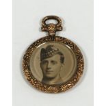 AN EARLY TWENTIETH CENTURY EMBOSSED 9ct GOLD AND GLAZED CIRCULAR DOUBLE SIDED PHOTOGRAPH LOCKET