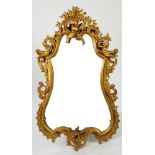 GILT GESSO WALL MIRROR, the cartouche shaped plate in a moulded frame with pierced floral border