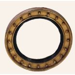 NINETEENTH CENTURY CONVEX WALL MIRROR, the circular plate with ebonised slip and gilt gesso