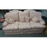 A LOUNGE SUITE OF FOUR PIECES, COVERED IN PINK FLORAL FABRIC TO INCLUDE; A THREE SEATER SETTEE,