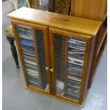 CD AND VIDEO STORAGE CABINET AND A LARGE SELECTION OF CD's AND THREE OPEN BOOKCASES