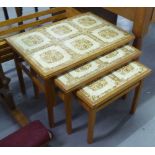 A NEST OF THREE TABLES WITH INSET TILE TOPS AND A WOODEN FRAMED PLANT TROUGH