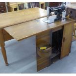 AN EARLY TWENTIETH CENTURY MAHOGANY SEWING MACHINE CABINET, SOLID DOORS REVEALING FITTED SINGLE