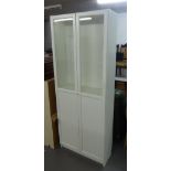 A MODERN WHITE MELAMINE TWO DOOR BOOKCASE, with glazed upper section opening to reveal four