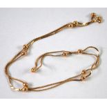 AN ITALIAN 9ct GOLD FINE CHAIN NECKLACE, with eleven gold beads, 22" long, 4.5gms