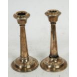 GEORGE V PAIR OF WEIGHTED SILVER CANDLESTICKS, of plain tapering form with circular bases, 5 1/2" (