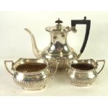 THREE PIECE SILVER COFFEE SET, of oval part reeded form with black angular scroll handle, oval bases