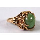 14K GOLD RING WITH A CABOCHON GREEN STONE within a floriated setting, 6.7 gms gross