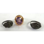 UNMARKED GOLD WIRE FRAMED RING the oval flower head pattern top set with large purple stone and