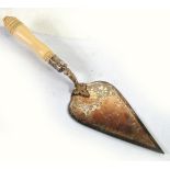 AN EDWARDIAN ELECTROPLATE TROWEL with bright cut engraved triangular blade on a foliate chase curved