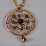 9ct GOLD CIRCULAR OPENWORK PENDANT set with centre garnet and seed pearls and having smaller pendant