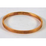 9ct GOLD HOLLOW BANGLE with engine turned decoration, 8.7 gms