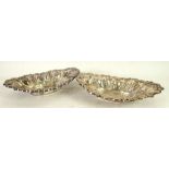 A MATCHED PAIR OF SILVER BOAT SHAPED BOWLS, the deep sloping sides having eight repoussé bombe