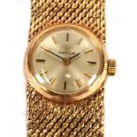 LADY'S OMEGA 9ct GOLD BRACELET WATCH, with mechanical movement, small circular silver dial with
