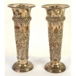 PAIR OF LATE VICTORIAN SILVER TRUMPET VASES with swollen collars, the bodies repoussé with flowers