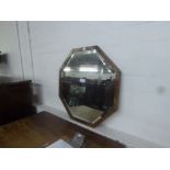 AN OCTAGONAL BEVELLED EDGE WALL MIRROR IN WALNUT FRAME