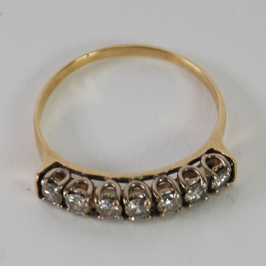 RING SET WITH A HALF HOOP OF SEVEN UNIFORM BRILLIANT CUT DIAMONDS, approx .70ct in total, 3.3gms