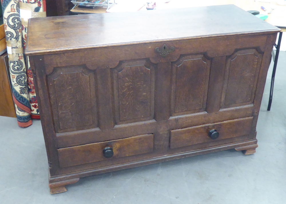 A LARGE 18TH CENTURY OAK DOWER CHEST WITH HINGED LID, FOUR PANEL FRONT, TWO DRAWERS BELOW, ON OGEE