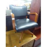 A POLISHED WOOD AND BLACK LEATHER UPHOLSTERED REVOLVING OFFICE CHAIR