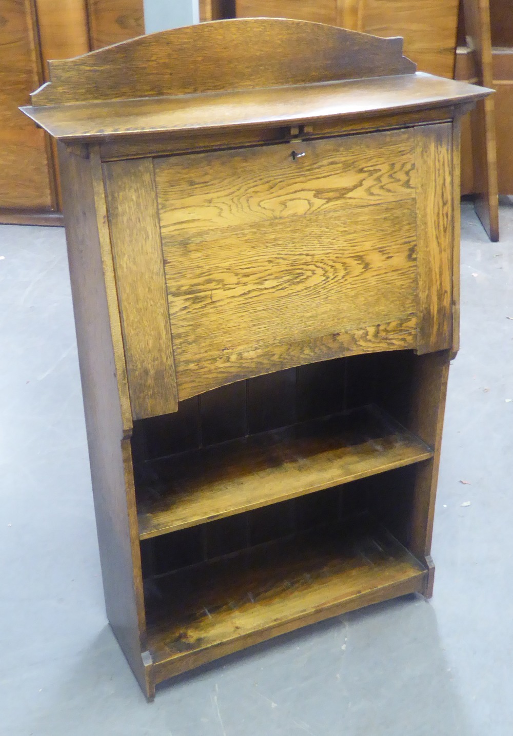 AN EARLY TWENTIETH CENTURY OAK FALL-FRONT WRITING BUREAU WITH OPEN SHELVES BELOW