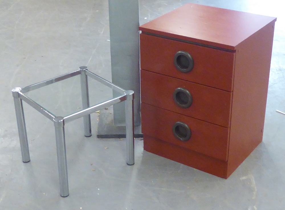 A GLASS TOPPED SQUARE COFFEE TABLE ON METAL TUBULAR LEGS AND A WOOD EFFECT SMALL CHEST OF THREE