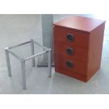 A GLASS TOPPED SQUARE COFFEE TABLE ON METAL TUBULAR LEGS AND A WOOD EFFECT SMALL CHEST OF THREE