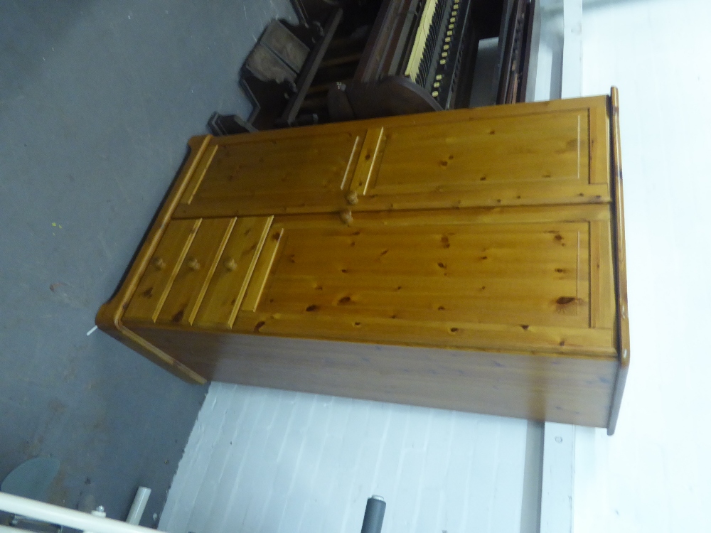 A PINE CHILD'S WARDROBE, WITH ONE LONG DOOR AND A SHORT DOOR OVER THREE SMALL DRAWERS, KNOB HANDLES