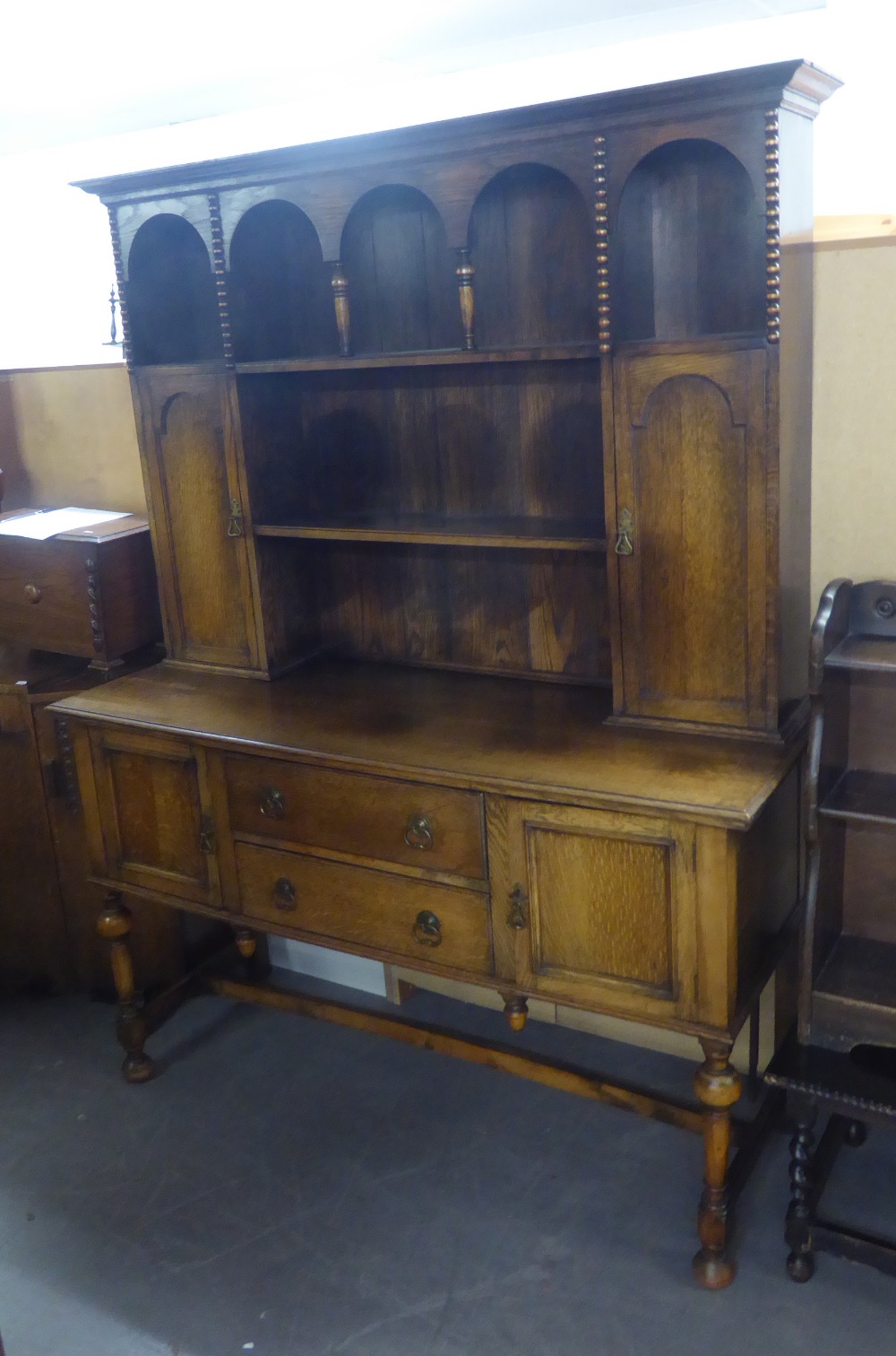 AN EARLY TWENTIETH CENTURY OAK DRESSER, the top section having open plate rack flanked by two