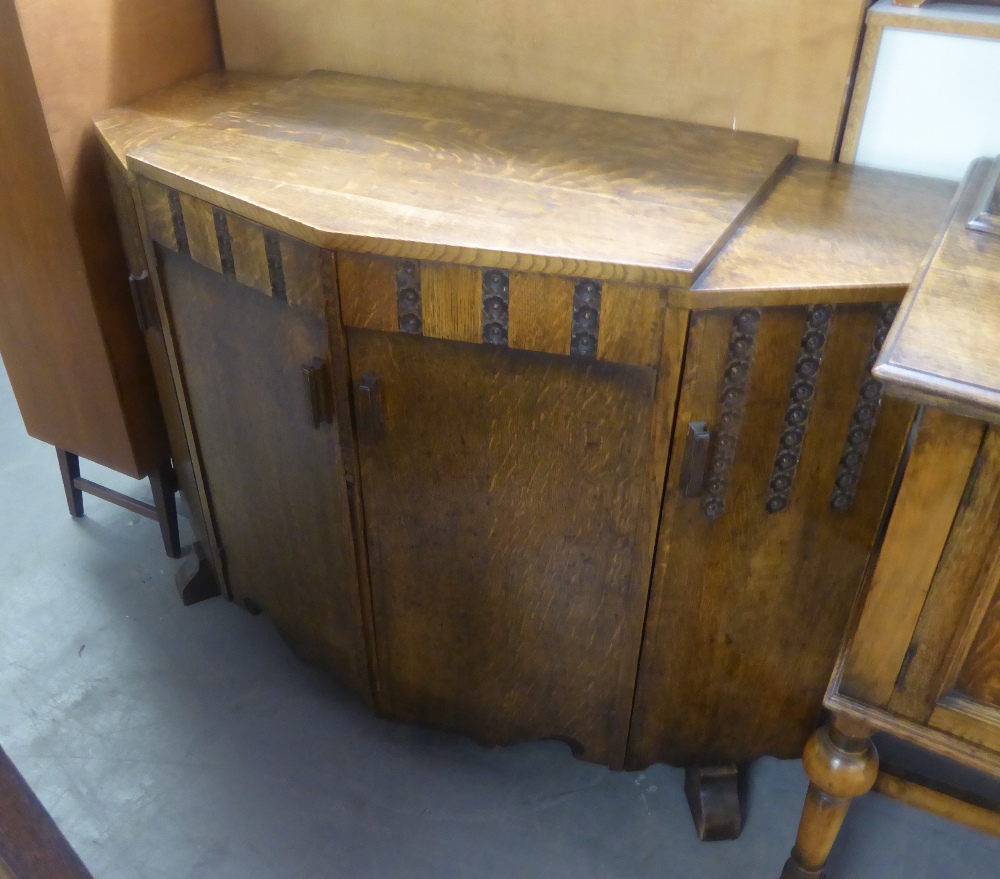 A TWENTIETH CENTURY OAK BREAKFRONT SIDEBOARD, THE CENTRE CUPBOARD ENCLOSING TWO SLIDES OVER SHELF