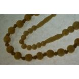 THREE CARVED BEAD NECKLACES AND A WHITE SHELL BEAD NECKLACE