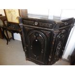 A NINETEENTH CENTURY EBONISED AND CARVED SIDE CABINET WITH CANTED SIDES, 48" HIGH, 47" WIDE, AND A