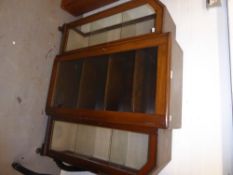 AN ART DECO WALNUT BREAKFRONT BOOKCASE, WITH GLAZED DOOR AND END DISPLAY SECTIONS, EACH WITH A